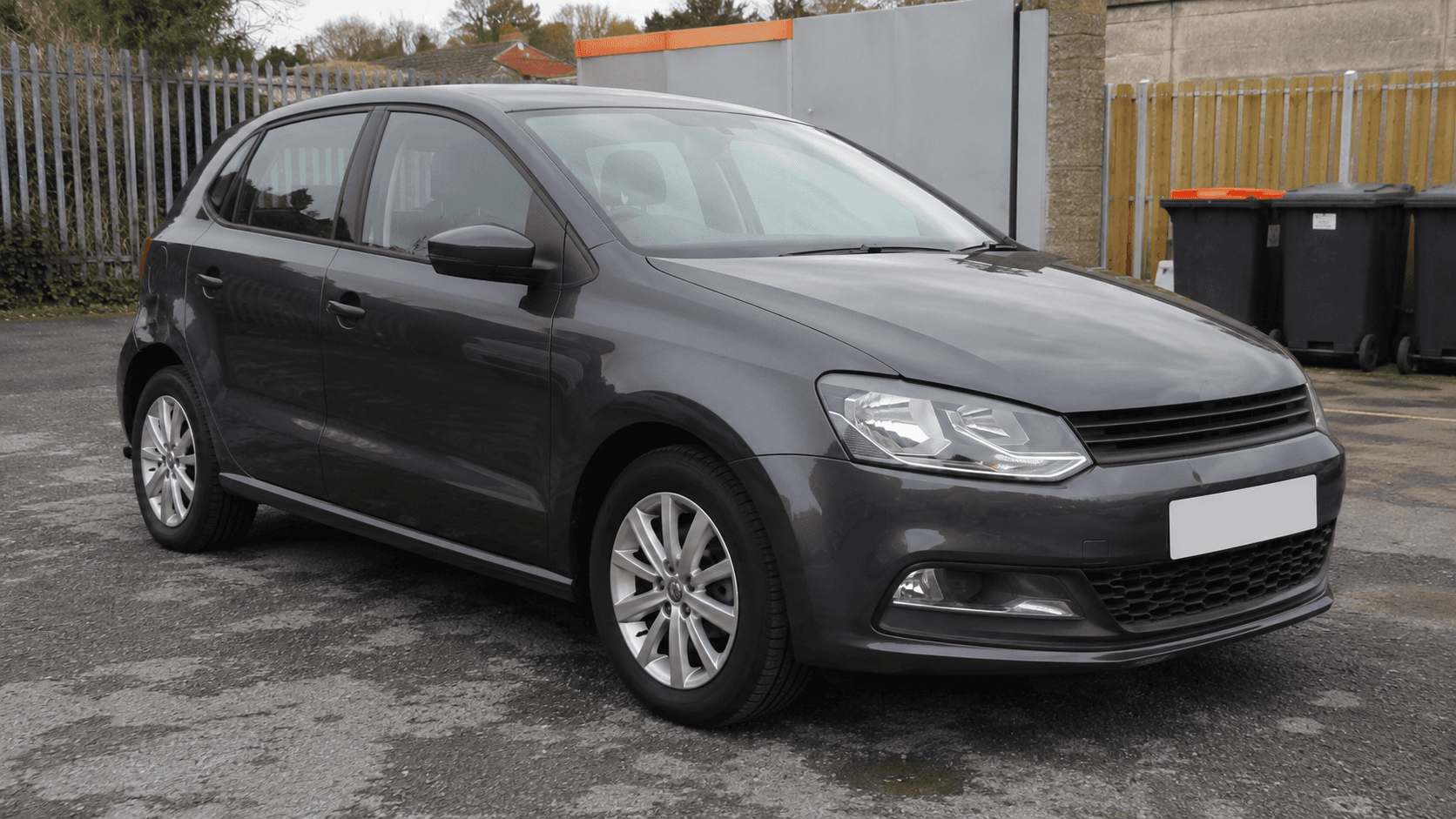 Unbranded vehicle photographed in a cluttered setting before background treatment
